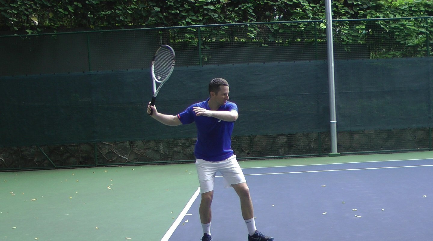 about to hit a tennis ball